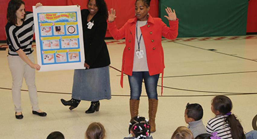 Beth Gray and Lisa Sweed, with the Sumner County Health Department, hold up a handwashing diagram as Kimberly Bonds talks to students in Hendersonville