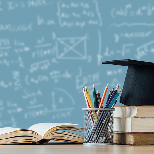 math formulas on a chalkboard with educational books in the foreground