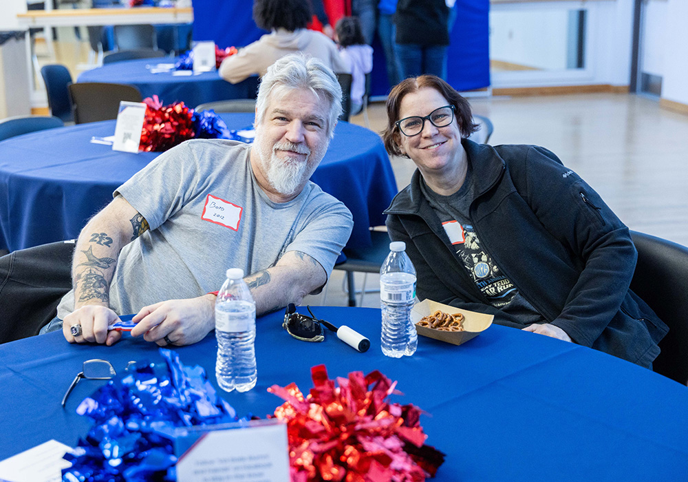 Two alumni chatting with each other at Spirit Night on February 7
