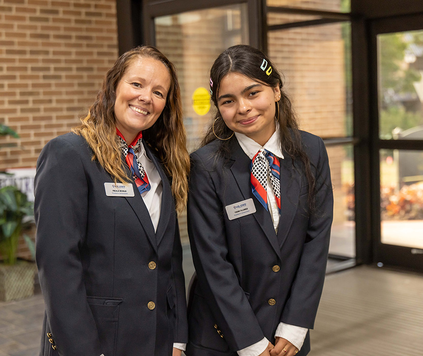 two female student ambassadors dressing nicely and working a college function