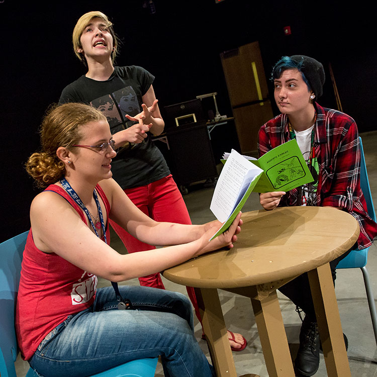 three students rehearsing a play