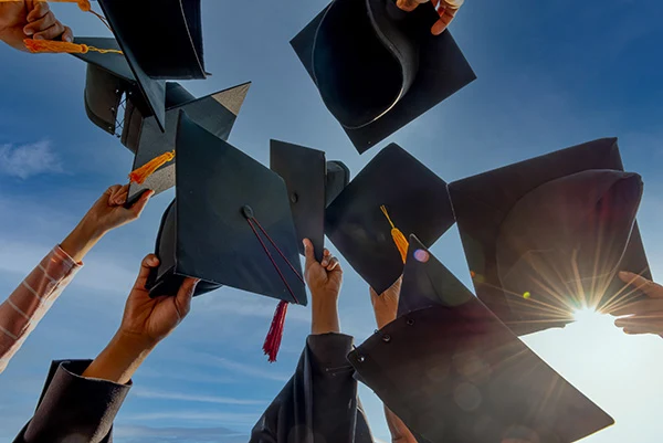 graduates holding their caps in the air