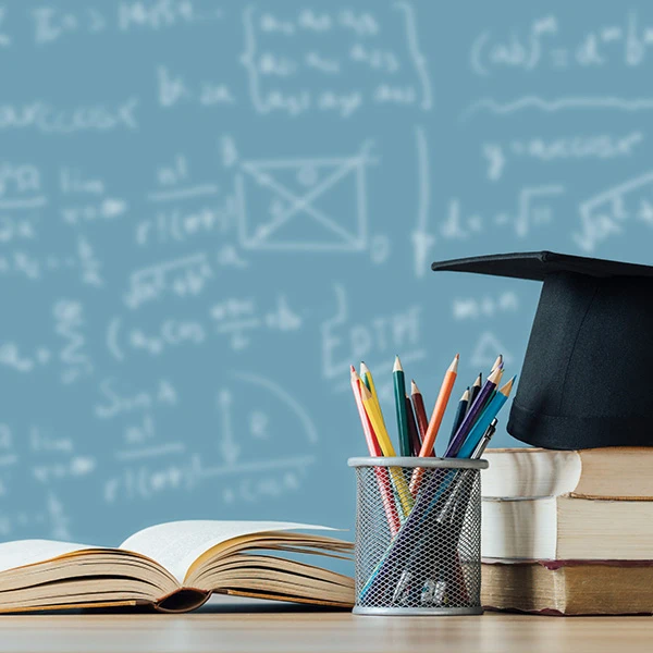 math formulas on a chalkboard with educational books in the foreground