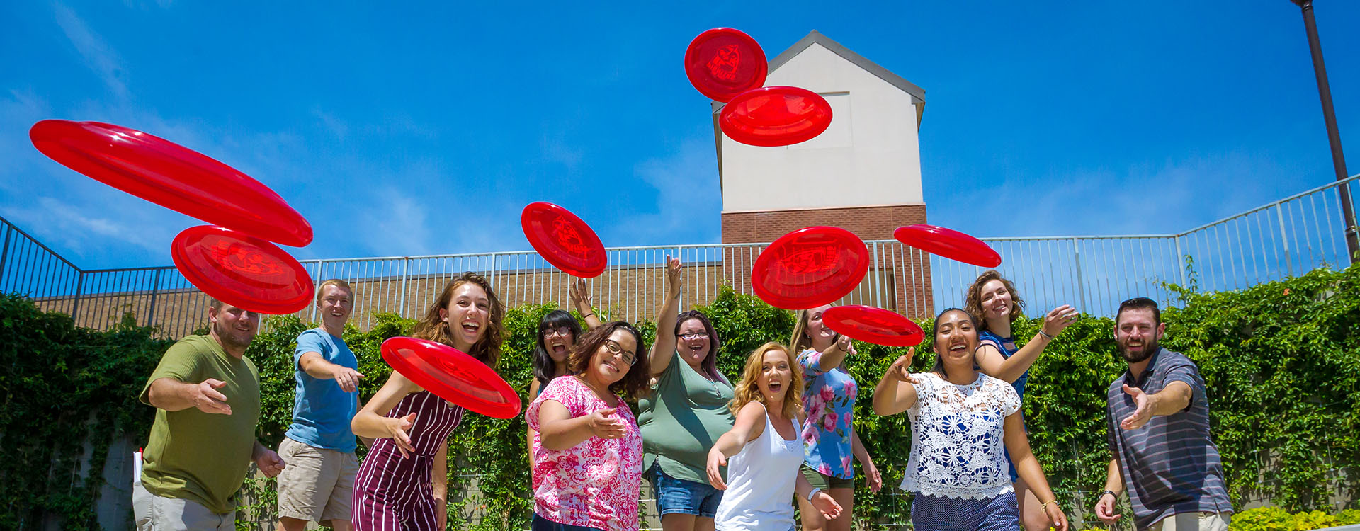 students throwing red frisbies