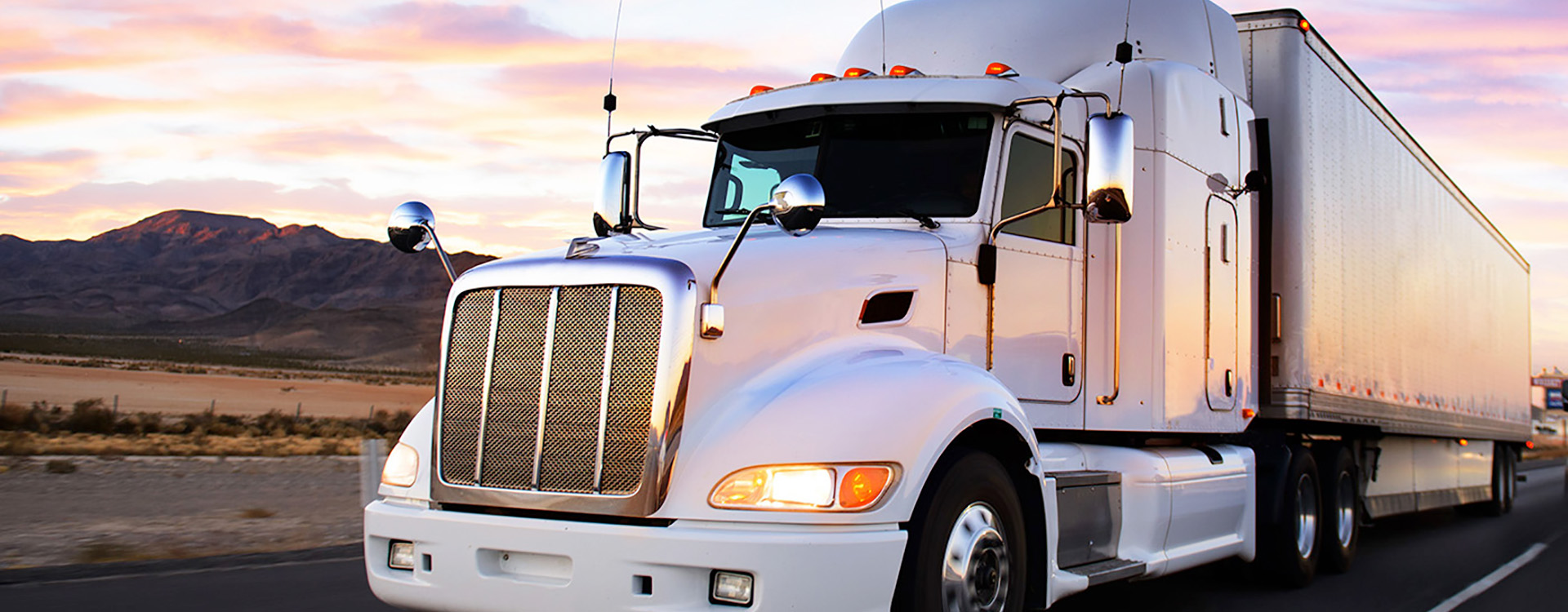 A white 18-wheeler truck carrying freight