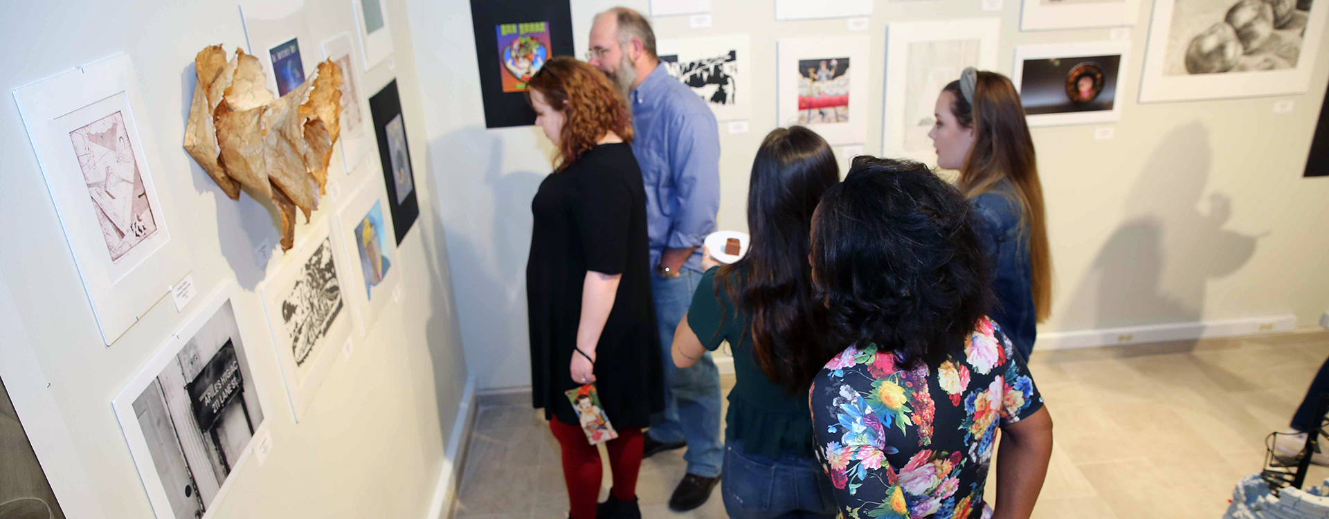 public viewing a student art show on campus