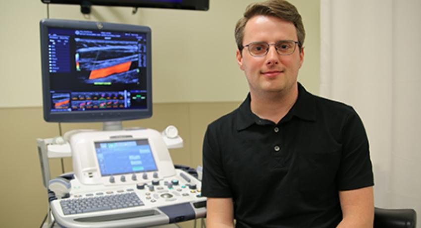 sonography director sitting beside equipment