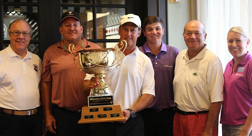 golf tournament winners holding a trophy