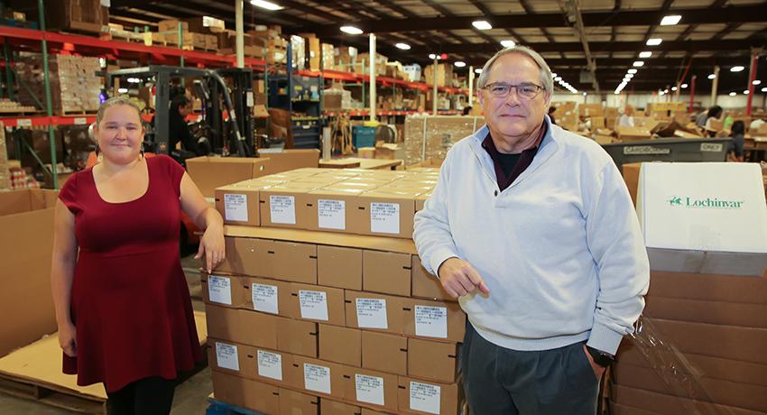 Kelly Dean and Royce Dugan on a warehouse floor at TNT Supply Chain Services. 