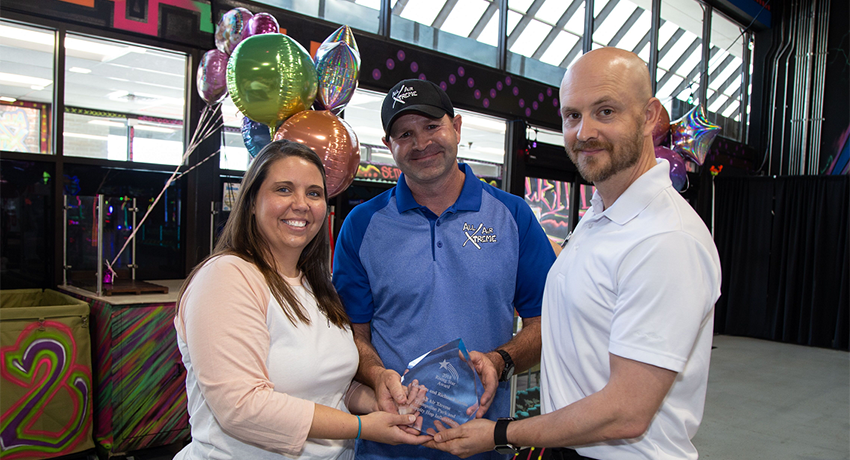 Kandace and Richard Martin, owners of All Air Xtreme Trampoline Park and Hoppity Hop Inflatables, receive the award from Charles Alexander with the TSBDC.
