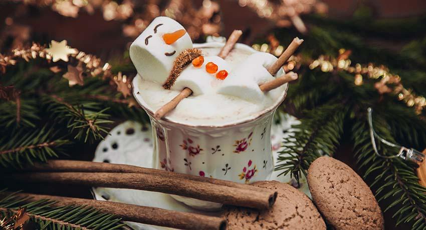 A marshmallow snowman floating in a cup of hot chocolate