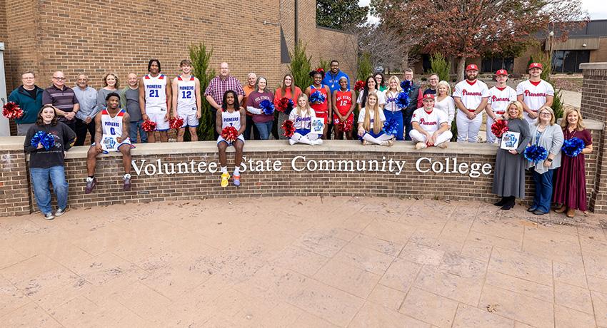 staff, faculty, and student celebrate in front of the Vol State sign