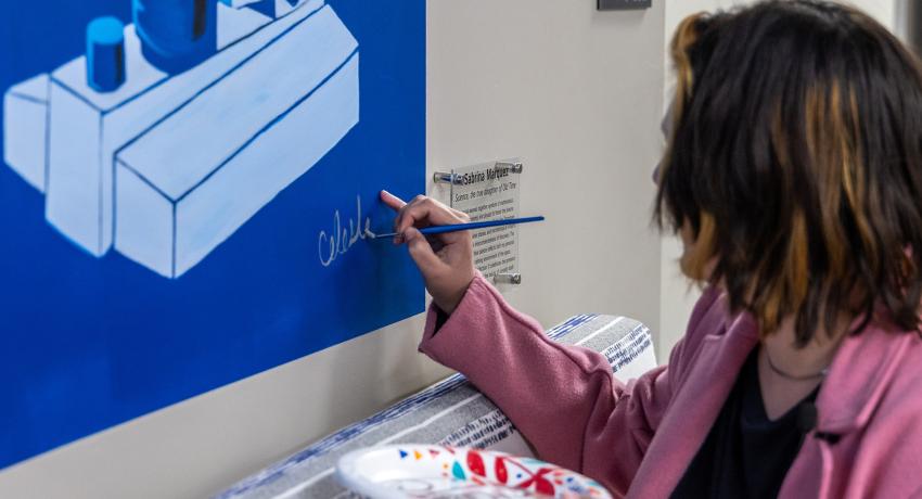 Vol State Art Student, Sabrina Marquez, signing her mural