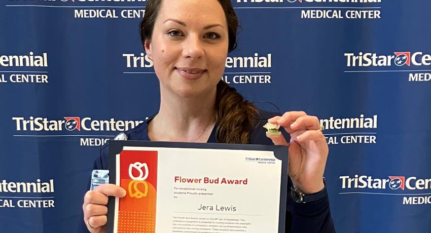 Jera holding the award certificate and the Flower Bud pin