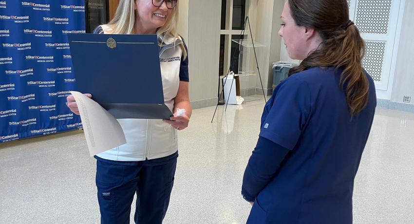 Jera discussing her award with a professor