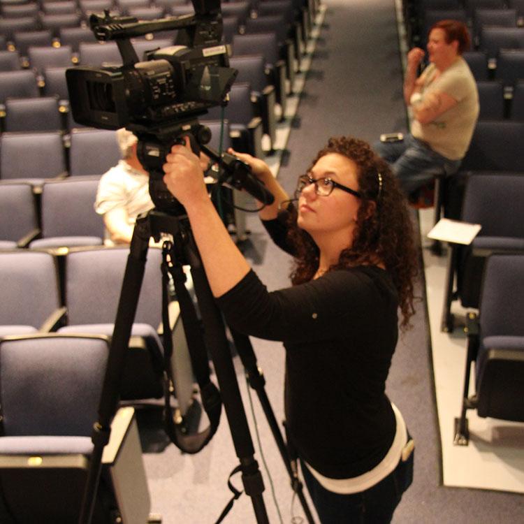 student filming with a video camera