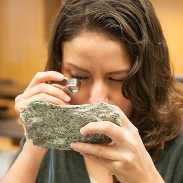 student examining a rock