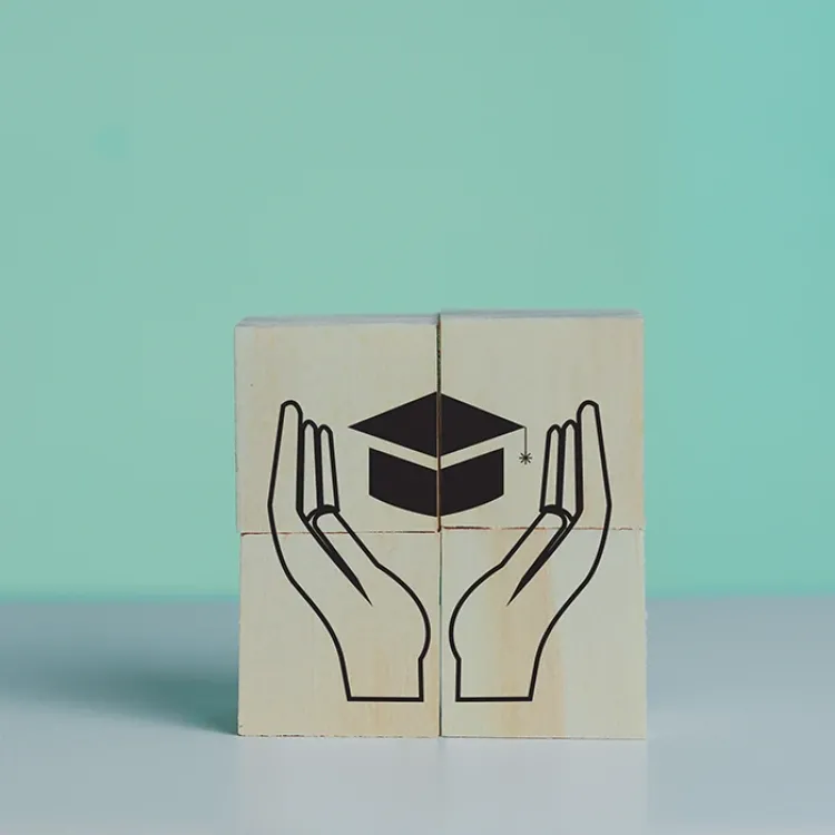 image of hands helping one to graduate