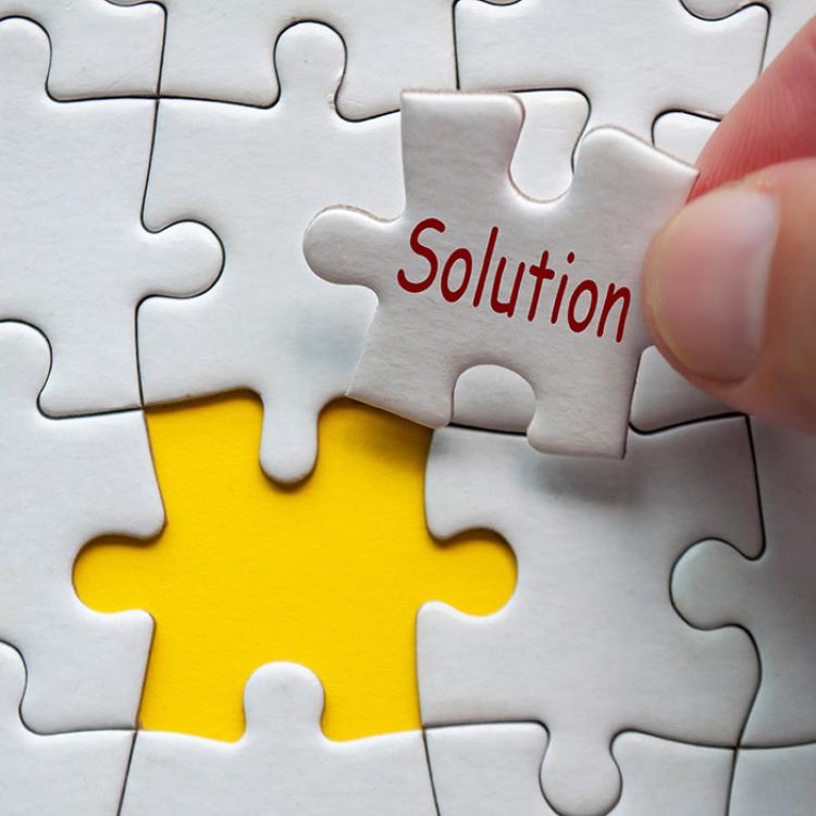 putting a puzzle together with the last piece having the word solution on it